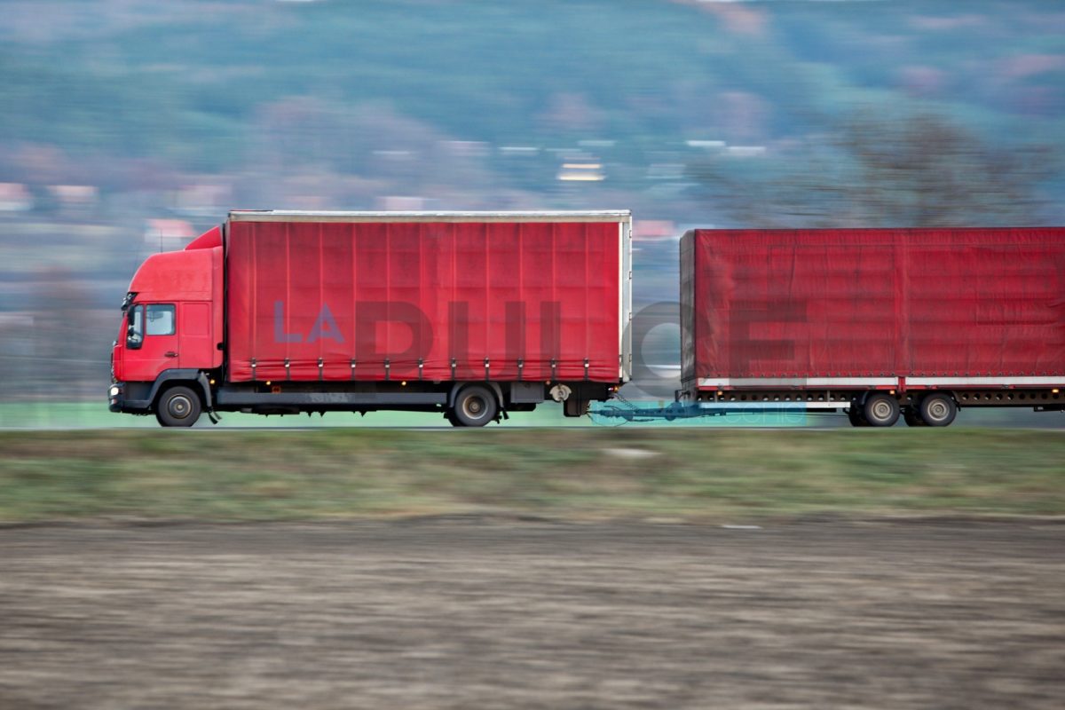 red camion/truck goes fast on a road (panned image - motion blur