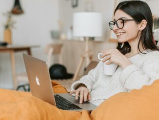 woman having coffee while using laptop