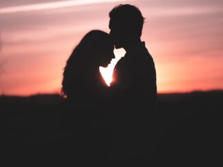 a silhouette of a couple kissing